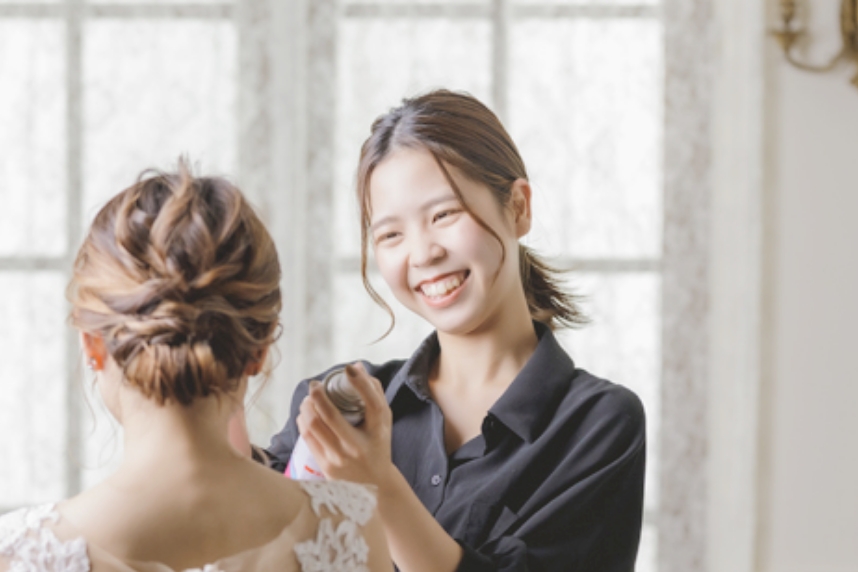 花嫁にヘアメイクしている小松さんの写真